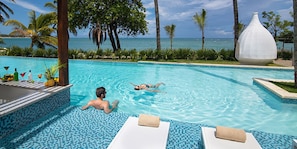A pool area with two lounge chairs, a large decorative vase, and a view of the ocean. - Imperial Suite 3-bedroom Ocean View and Kitchen (Sosúa)