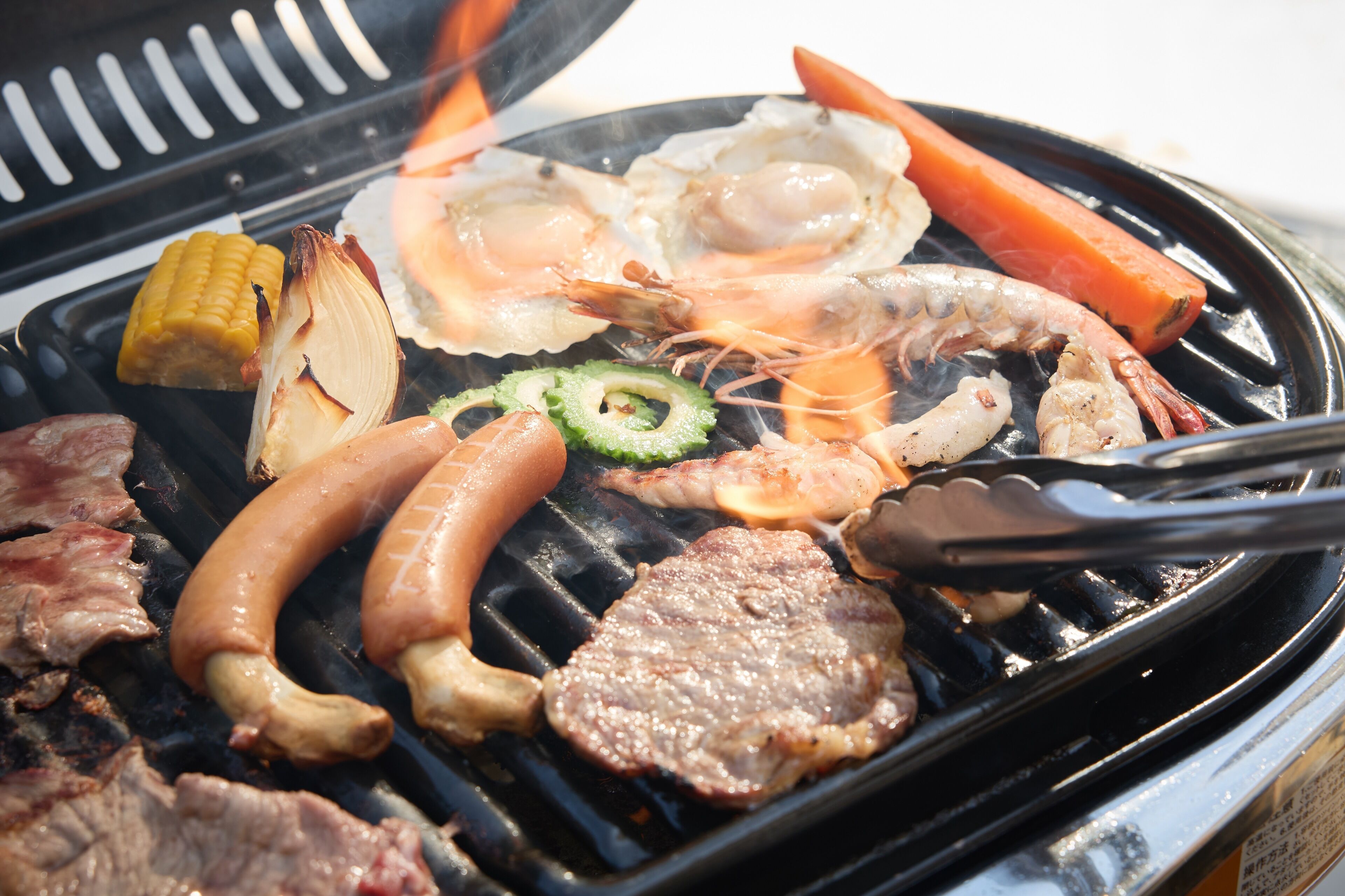Ein Grill mit verschiedenen Fleischsorten und Gemüse.