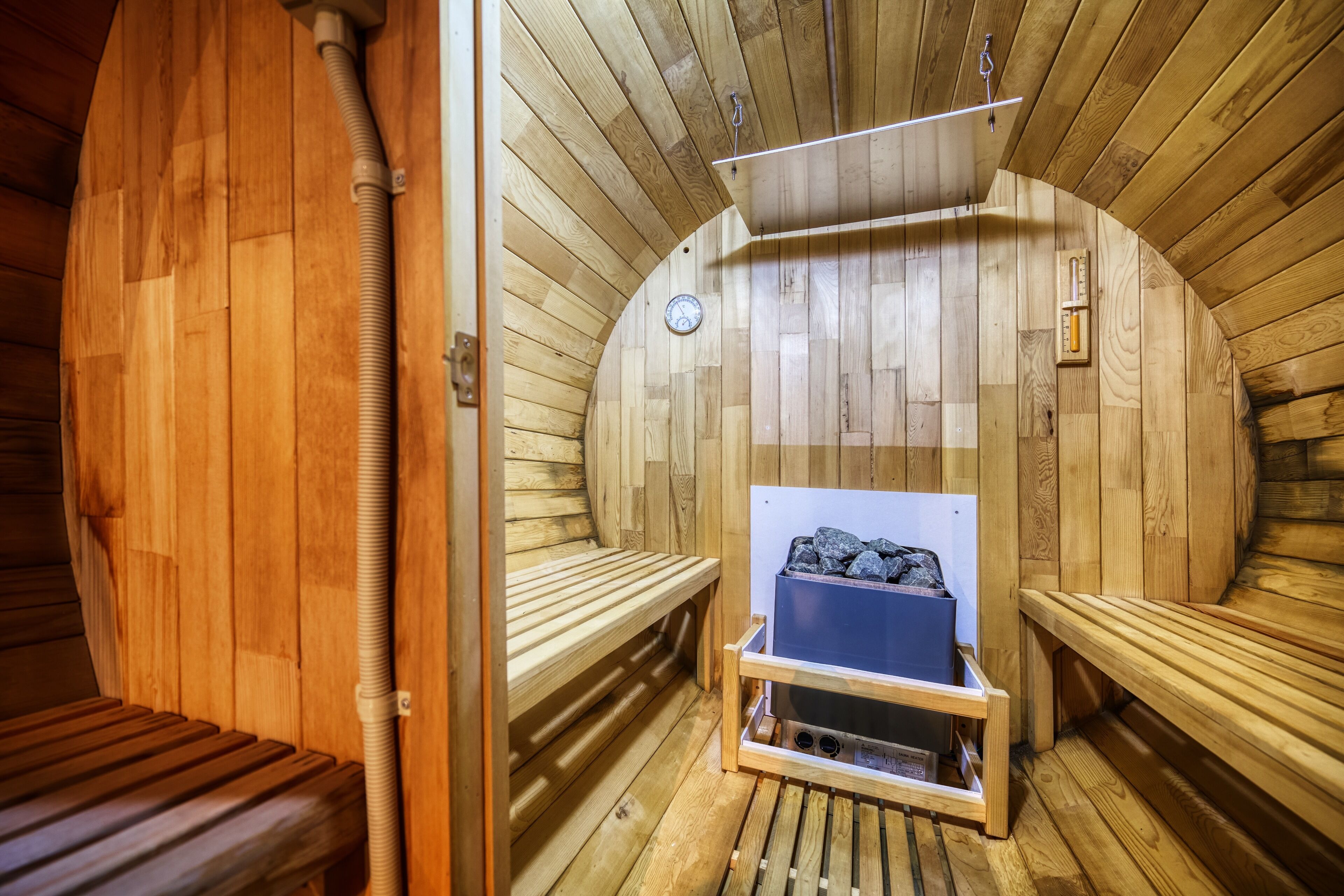 A wooden sauna with benches and a bench with a heater.