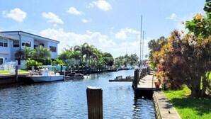 A waterfront property with a dock, a building with a balcony, and a marina with boats. - Charming Waterfront Oasis, Quiet Island Near Beach (Fort Lauderdale)