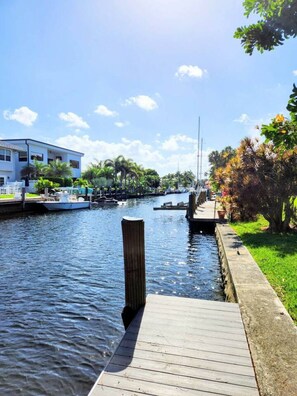 A waterfront property with a dock, a building with a balcony, and a marina with boats. - Charming Waterfront Oasis, Quiet Island Near Beach (Fort Lauderdale)