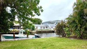 A waterfront property with a dock, a house, and lush greenery. - Charming Waterfront Oasis, Quiet Island Near Beach (Fort Lauderdale)
