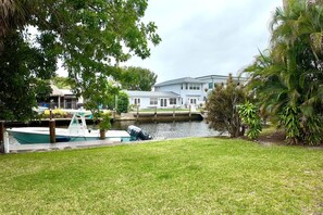 A waterfront property with a dock, a house, and lush greenery. - Charming Waterfront Oasis, Quiet Island Near Beach (Fort Lauderdale)