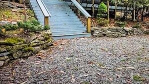 A modern house with a wooden staircase leading to a covered porch. - 3 BR Beech Mtn Basecamp: 2 Mi to Resort, Fireplace & Firepit (Beech Mountain)