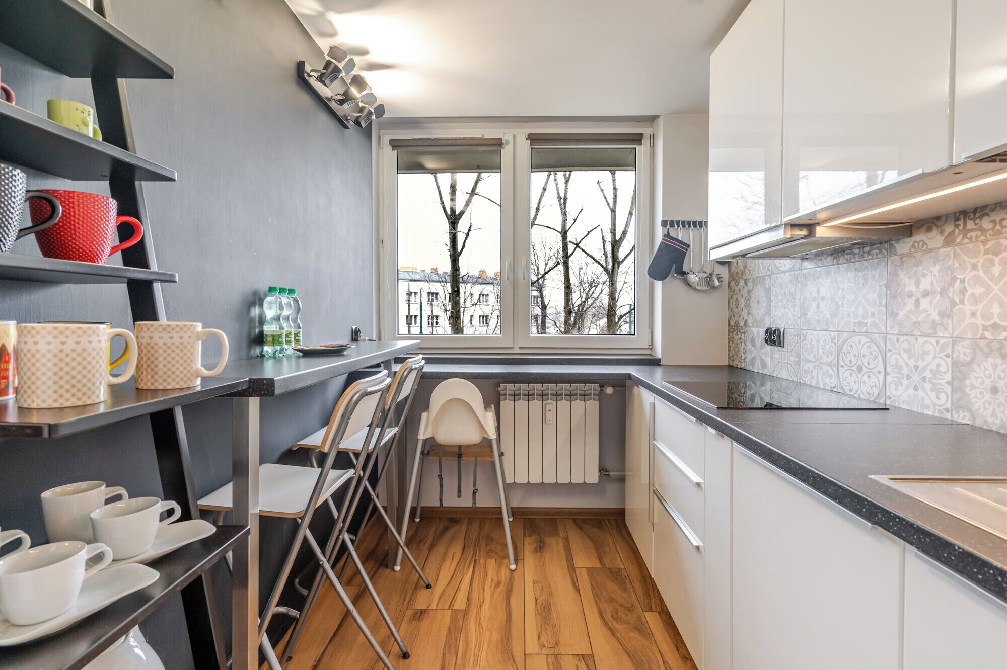A compact kitchen with a window, a radiator, and a countertop.