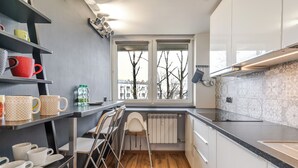 Una cocina pequeña con ventana, un radiador y una encimera.