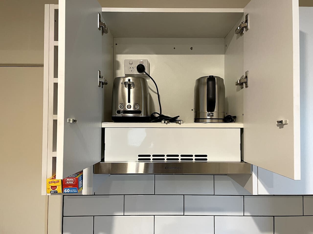 Een keuken met een inbouwoven en een afzuigkap.