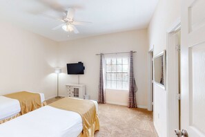 A bedroom with two beds, a ceiling fan, a TV, a window with curtains, and a door. - 3rd floor condo w/ pools, balcony, sauna, gym, hot tub, near theme parks (Kissimmee)