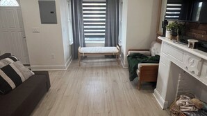 Una habitación con cama, sofá, televisor y chimenea.