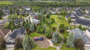 Un quartiere residenziale con case, un parco giochi e un parco.