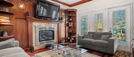 A living room with a fireplace, a television, a sofa, and a coffee table.