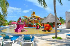 A water park with colorful play structures, a thatched-roof hut, and lounge chairs. - Room-junior Suite by All Ritmo Cancun Re (Cancun)