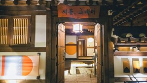 A traditional wooden entrance with a sign, a brick wall, and a tiled floor. - Seoul Hanok Stay Circle (Seoul)