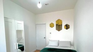 Un dormitorio con cama, armario y puerta.