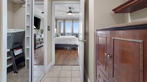 A bedroom with a bed, a ceiling fan, a dresser, and a view of the outdoors. - Amazing Gulf Views! Legacy Towers 10th Floor! (Gulfport)