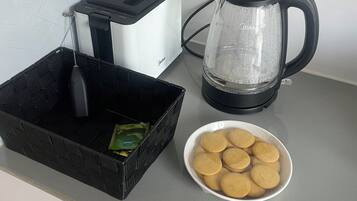 Eine Küchenarbeitsplatte mit einem Toaster, einer Kaffeemaschine, einem Korb mit einem Pfannenwender und einer Schüssel Kekse.