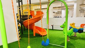 A children's play area with swings, slides, and a climbing structure.