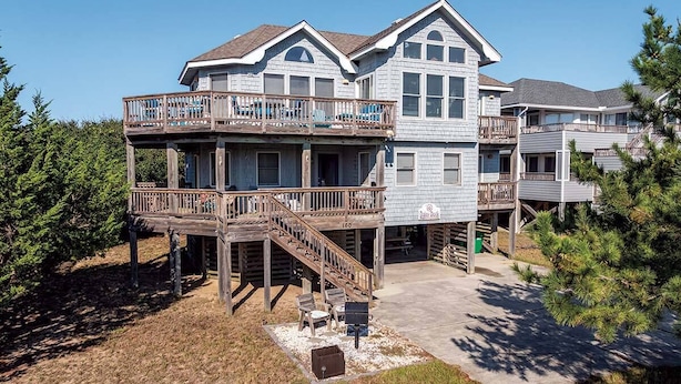 A two-story house with a deck and a covered outdoor seating area. - Daisy Duck - 5 BR Semi-Oceanfront Home in Schooner Ridge, Duck (Duck)
