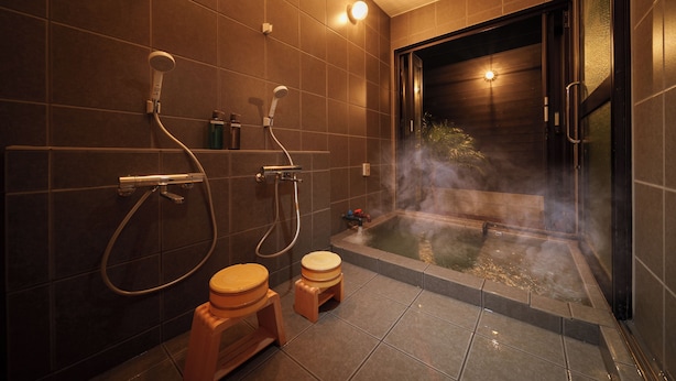 Un baño moderno con bañera, dos inodoros y ducha.