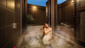 Un espacio de spa con un jacuzzi, un banco y una planta en maceta.