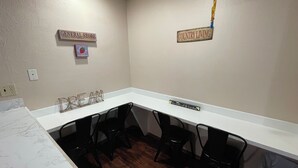 A conference room with a white table, black chairs, and wooden signs on the walls.