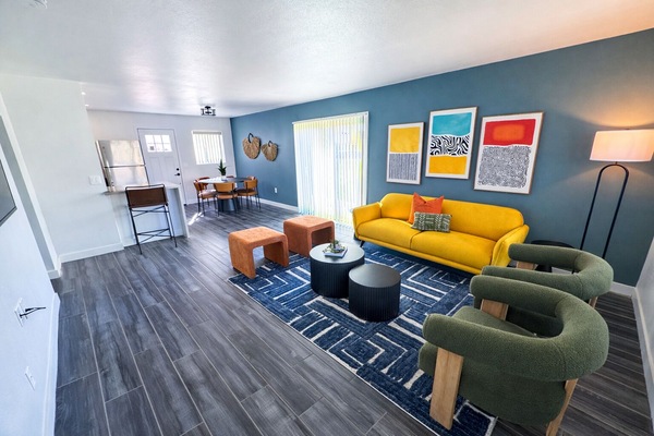 Bright and open living area featuring plush furnishings, a smart TV, and access to the private patio.