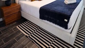 Un dormitorio con cama, mesita de noche, lámpara y ventilador de techo.