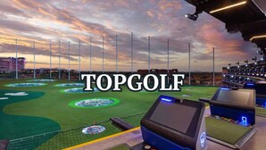 Un campo de golf con varios puntos de salida, un área cercada con red y un marcador de puntuación.