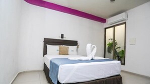 A neatly made bed with white linens and a blue blanket, a headboard, and a single pillow. - Modern Downtown Retreat | Comfortable and Convenient Stay in Cancun (Cancún)