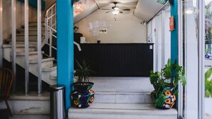 A reception area with a staircase, potted plants, and a ceiling fan. - Modern Downtown Retreat | Comfortable and Convenient Stay in Cancun (Cancún)