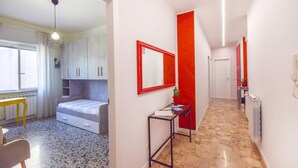 A narrow hallway with a bed, a desk, and a mirror. - Cozy apartment in Savona with WiFi (Savona)