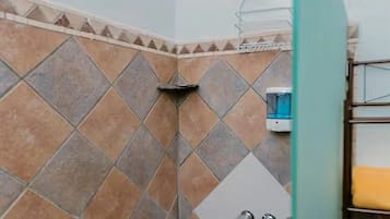 Een douche, handdoeken, zeep, toiletpapier