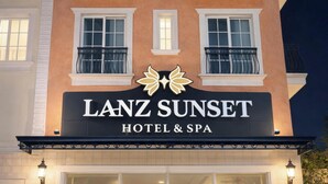 A hotel facade with balconies, large windows, and a sign reading "LANZ SUNSET HOTEL & SPA". - HAN Sunset Milan Hotel & Spa (Phu Quoc)