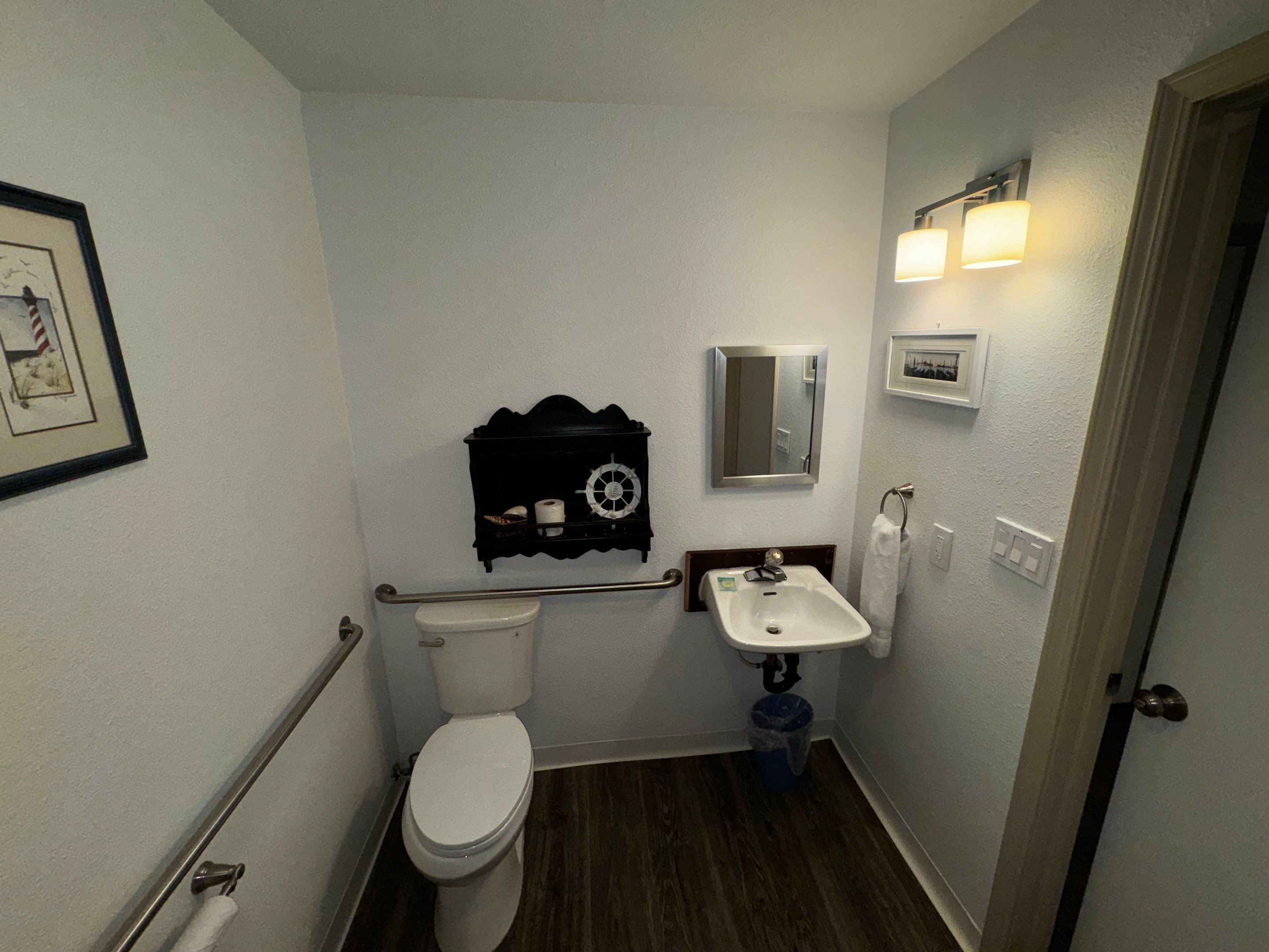 Une petite salle de bain avec des toilettes, un lavabo et un miroir.