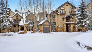 A multi-story hotel with stone and wood exteriors, multiple balconies, and snow-covered surroundings. - Misty Maiden Lodge by Avantstay Prime Ski-in Ski-out Retreat + Hot Tub + Steps to Lift & Gondola (Telluride)