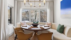 A dining area with a round table, chairs, a chandelier, and a sofa. - Misty Maiden Lodge by Avantstay Prime Ski-in Ski-out Retreat + Hot Tub + Steps to Lift & Gondola (Telluride)