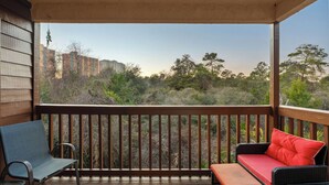A balcony with a view of buildings and trees, a chair, and a sofa. - Beachwalk 10B by Avantstay PCB Condo Across From the Beach + Pool & Tennis Court (Panama City Beach)