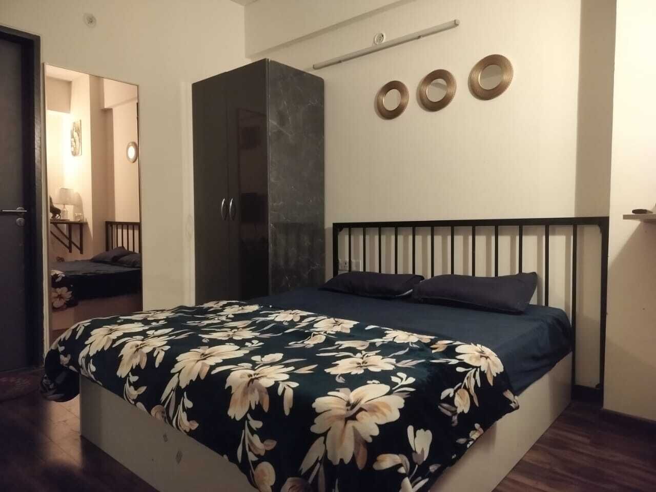 A bedroom with a bed, a wardrobe, and a mirror.
