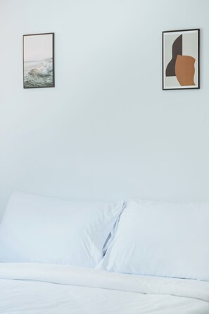 A bed with white linens and two framed artworks on the wall above it. - Sleep Pop CMU Chiang Mai (Chiang Mai)