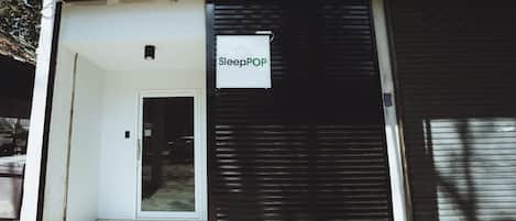 Tienda cerrada con un letrero que dice 'SleepPOP' y una persiana metálica bajada.