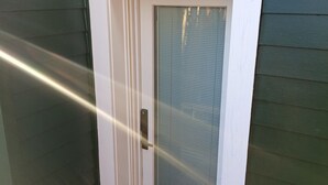 Eine weiße Tür mit Glasfenster und Metallbeschlag.
