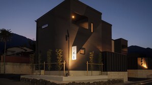 Un bâtiment moderne au design minimaliste, caractérisé par une enseigne verticale bien visible, ornée de caractères japonais.