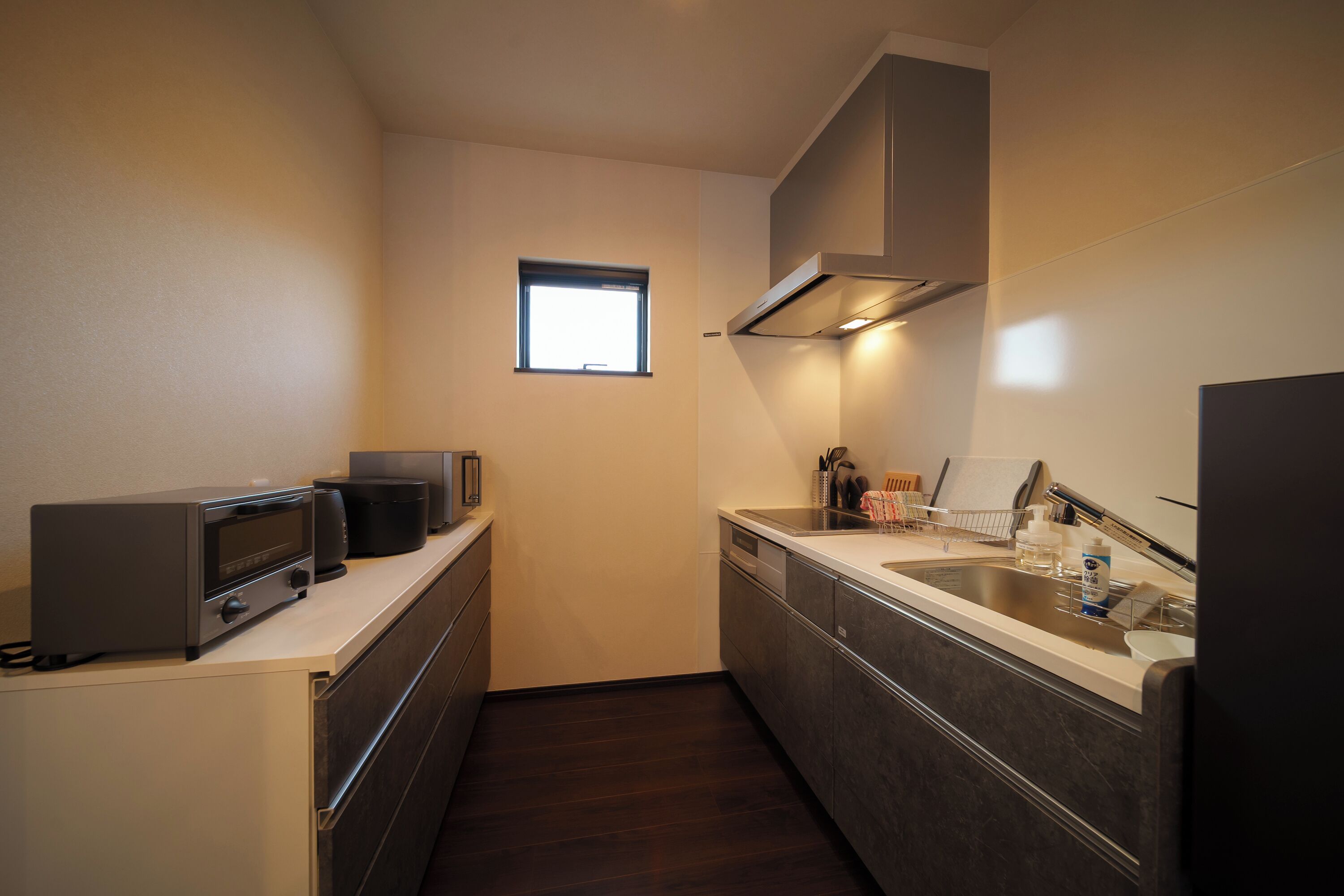 A compact kitchen with a microwave, toaster, and sink.