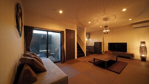 Un salon moderne avec un canapé, un téléviseur et un coin repas.
