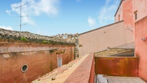 Une ruelle étroite avec un toit recouvert de tuiles, une petite porte et une fenêtre.