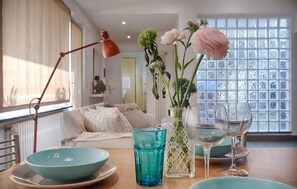 A dining area with a table set for two, featuring a blue bowl, a glass, and a vase with flowers. - Pet friendly apartment in Camaiore with WiFi (Camaiore)