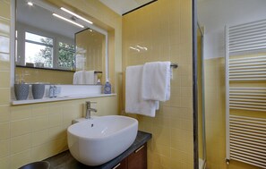 A bathroom with a white sink, yellow tiles, a mirror, and a towel rack. - Pet friendly apartment in Camaiore with WiFi (Camaiore)