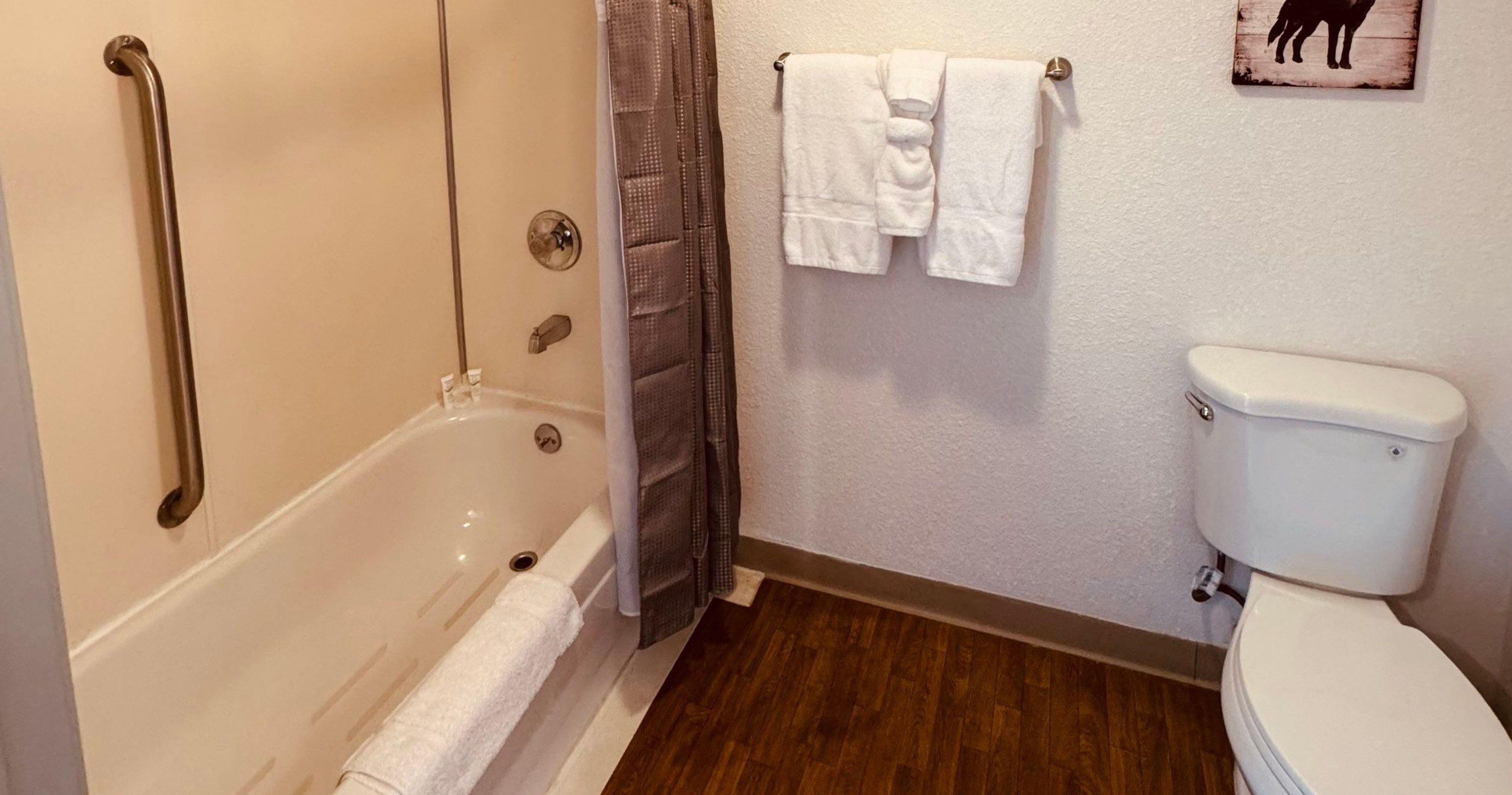 Une salle de bain avec une baignoire, des toilettes et un rideau de douche.