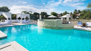 A pool area with a clear blue pool, a white canopy structure, and lounge chairs. - The Crown Oasis Luxury Escape All Inclusive (Puerto Plata)