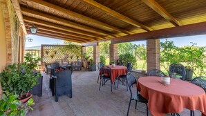An outdoor patio with wooden beams, brick walls, and potted plants. - Gorgeous apartment in Frazione Canonica,Todi (Frazione Canonica,Todi)